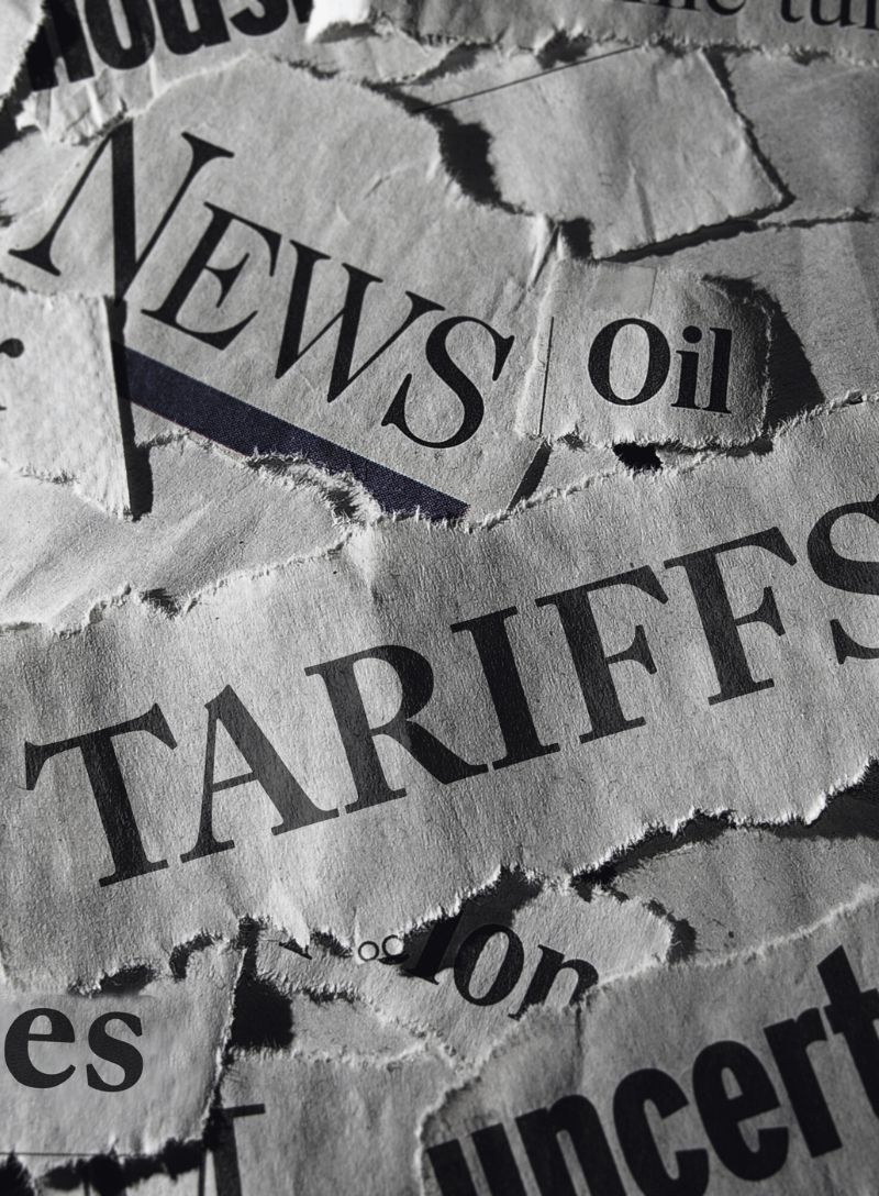Ripped news articles showing tariffs, oil, concert